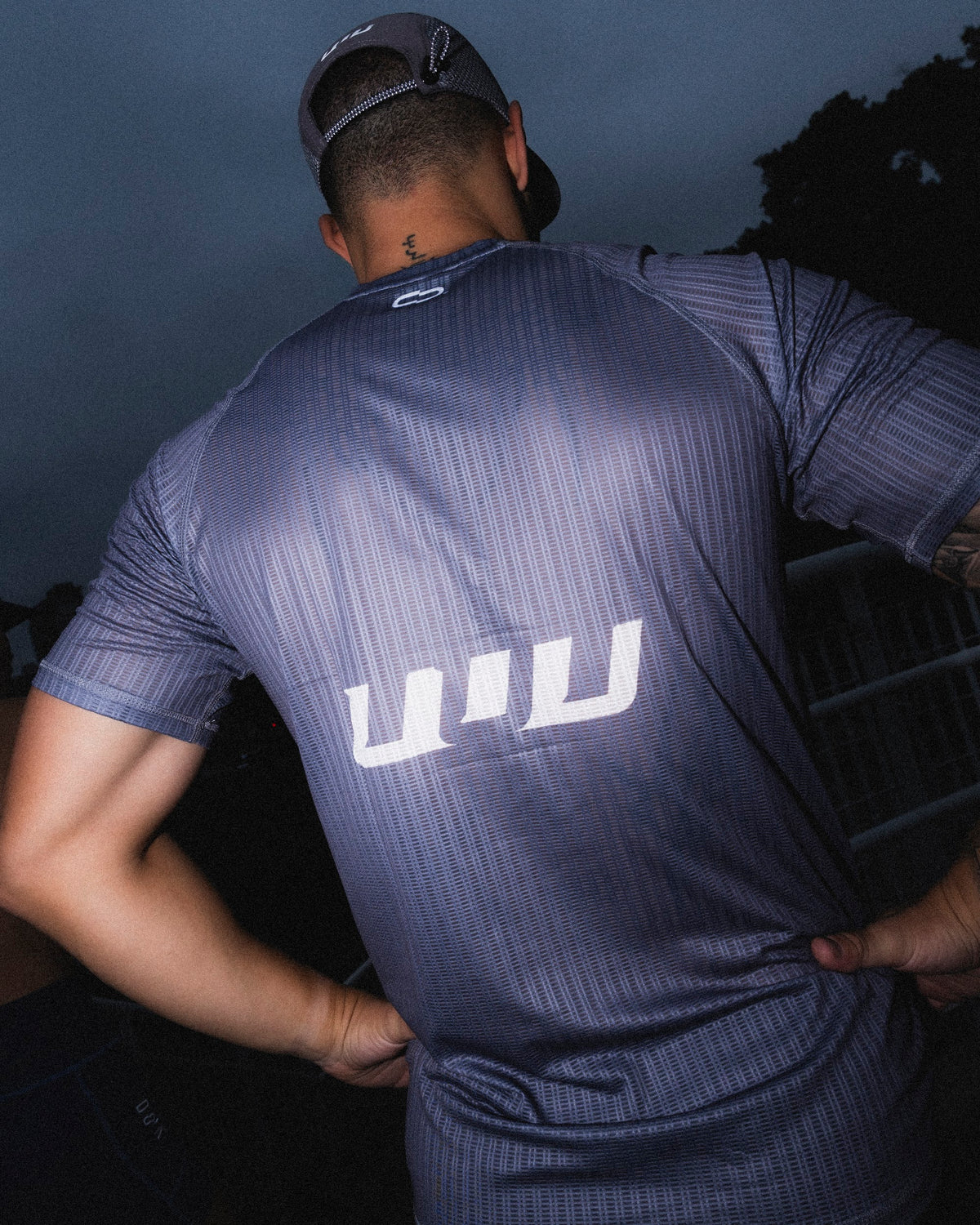 Atleta de costas com o símbolo UUU estampado na camiseta